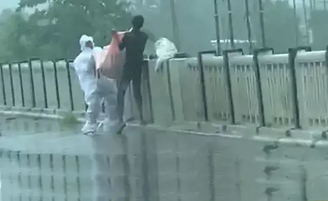 కరోనాతో మృతి చెందిన రోగిని నదిలోకి విసిరేస్తూ.. కరోనాతో మృతి చెందిన రోగిని నదిలోకి విసిరేస్తూ..